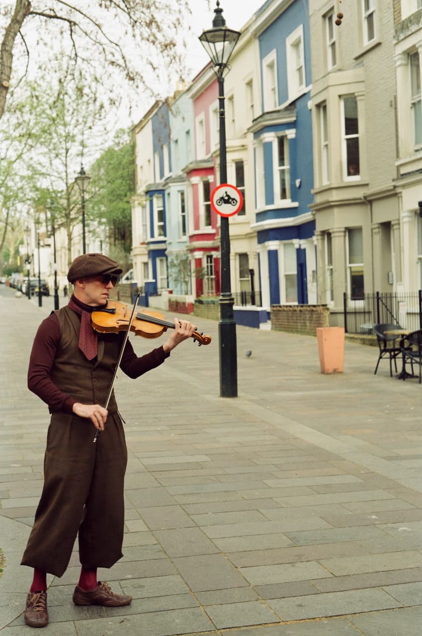Violinist playing on a London street with colourful terraced houses