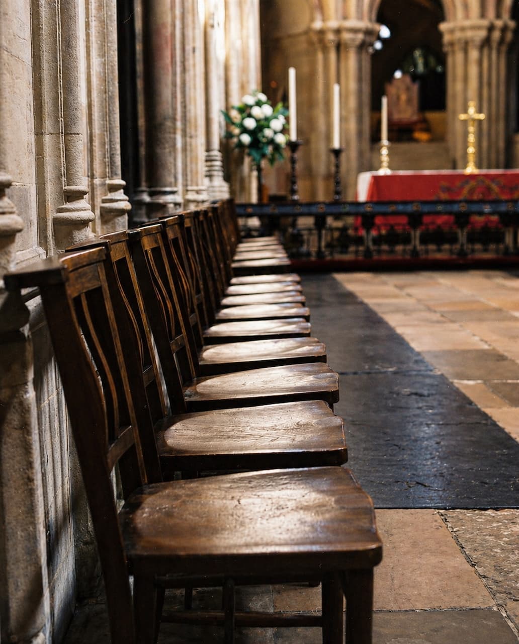 Wooden chairs lined up inside a cathedral