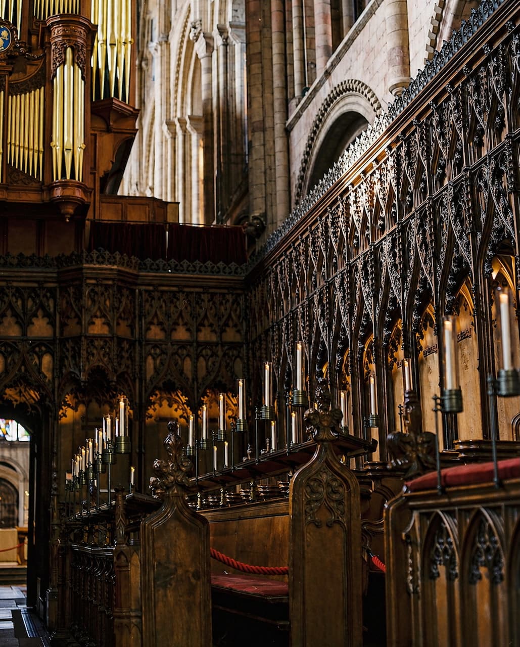 Carved wooden choir stalls and candlesticks inside a cathedral