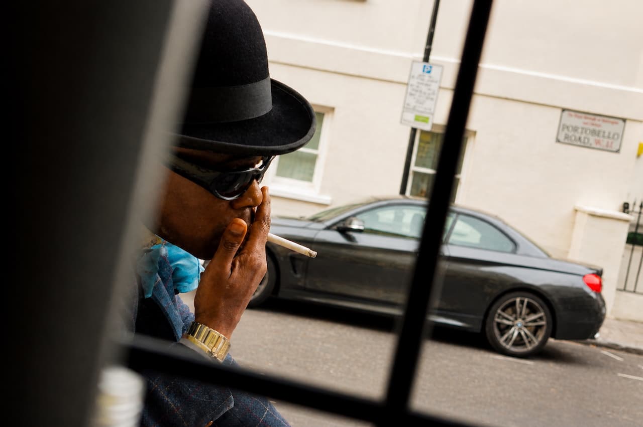 Man in bowler hat smoking on Portobello Road